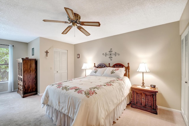 carpeted bedroom featuring a textured ceiling, ceiling fan, and a closet