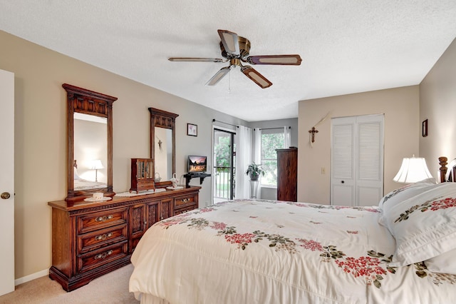 carpeted bedroom with a textured ceiling, a closet, access to exterior, and ceiling fan