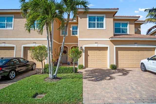 view of property featuring a garage and a front lawn