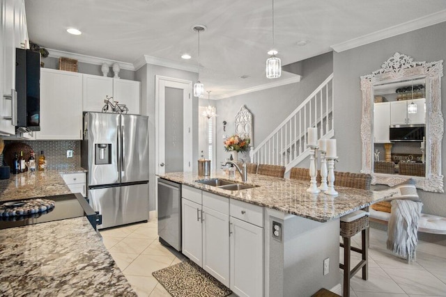 kitchen featuring stainless steel appliances, white cabinets, hanging light fixtures, and sink