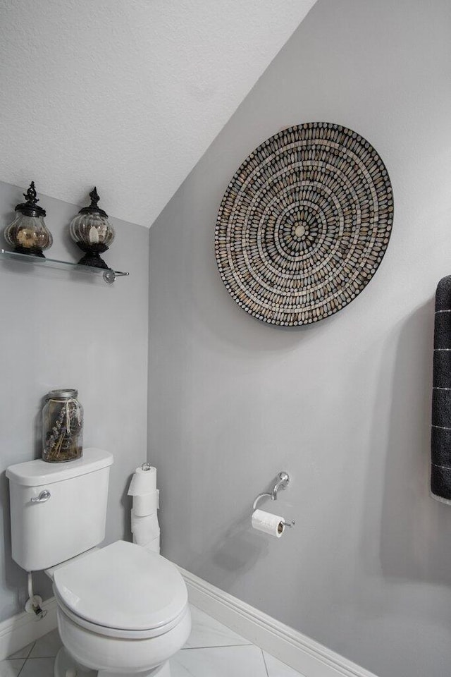 bathroom with toilet, tile patterned flooring, and a textured ceiling