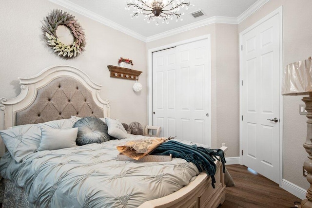 bedroom featuring a closet, dark hardwood / wood-style flooring, ornamental molding, and an inviting chandelier