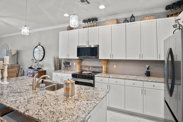 kitchen with pendant lighting, white cabinets, appliances with stainless steel finishes, decorative backsplash, and sink