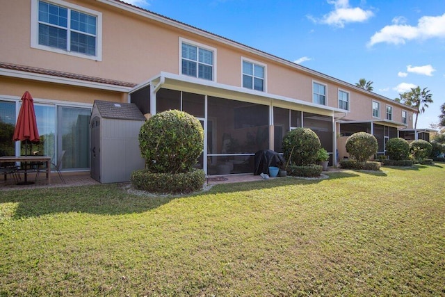 rear view of property with a sunroom and a yard