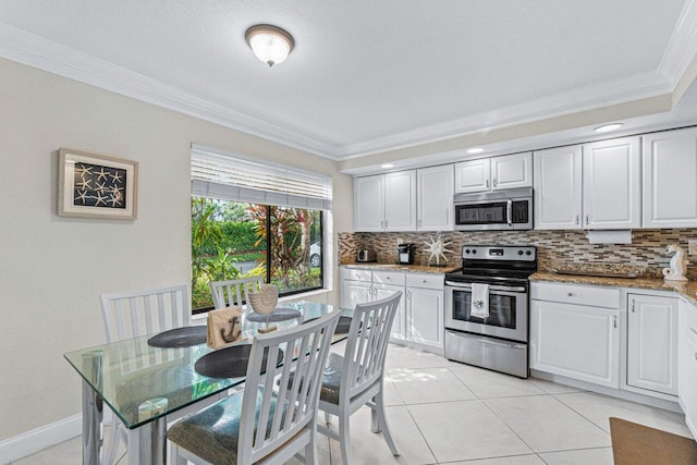 kitchen with white cabinets, ornamental molding, stainless steel appliances, and stone counters