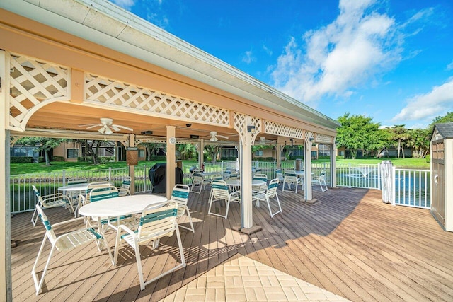 wooden deck with ceiling fan and a water view