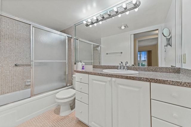 full bathroom with shower / bath combination with glass door, vanity, toilet, and tile patterned flooring