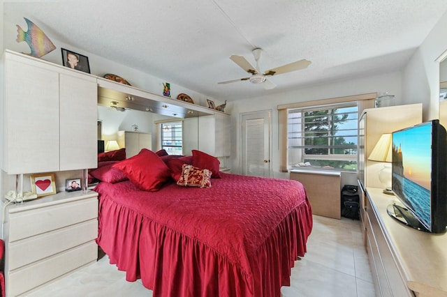 bedroom with ceiling fan and a textured ceiling