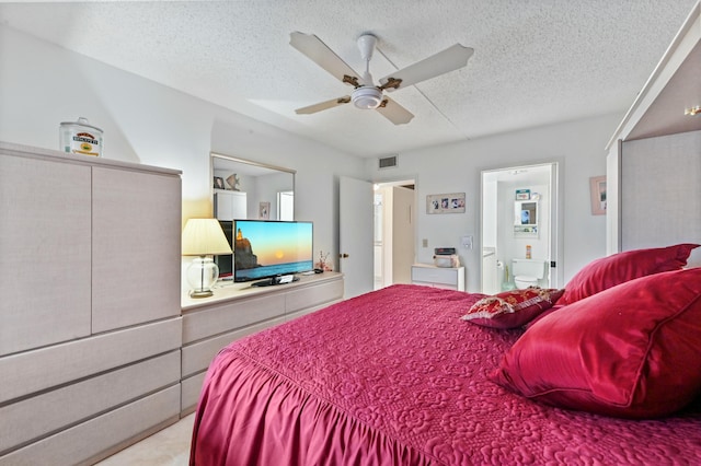 bedroom with a textured ceiling, ceiling fan, and connected bathroom