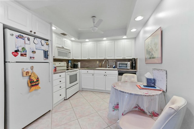 kitchen featuring ceiling fan, sink, a tray ceiling, white appliances, and white cabinetry