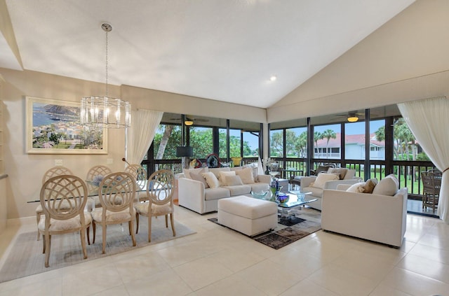 tiled living room featuring plenty of natural light, ceiling fan with notable chandelier, and high vaulted ceiling