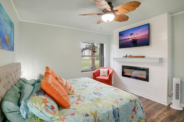 bedroom with ceiling fan, dark hardwood / wood-style flooring, a textured ceiling, and ornamental molding