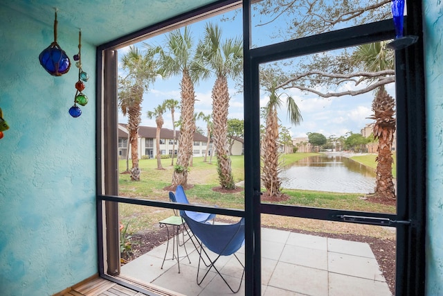 doorway with tile patterned floors and a water view