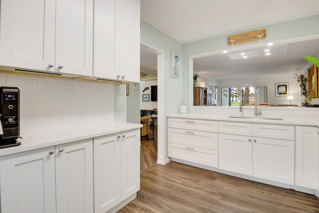 kitchen featuring light wood-type flooring, white cabinetry, and sink