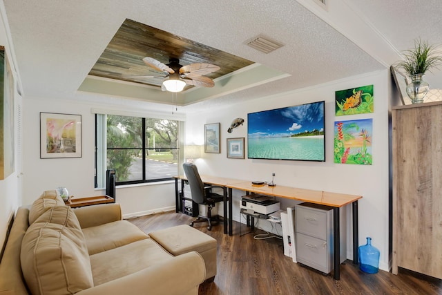 office with a textured ceiling, ornamental molding, dark hardwood / wood-style flooring, and a raised ceiling