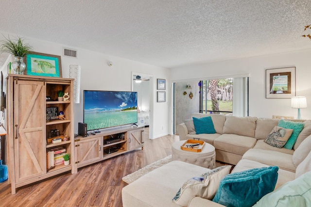 living room with wood-type flooring and a textured ceiling