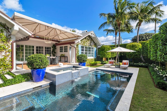 view of pool featuring pool water feature, a patio area, and an in ground hot tub