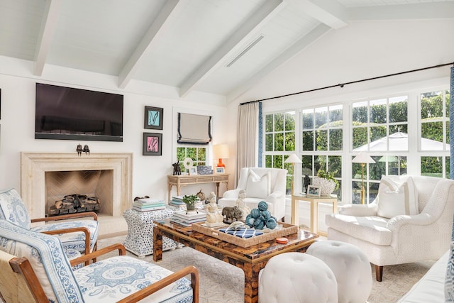 living room with a premium fireplace and vaulted ceiling with beams