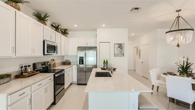 kitchen with an inviting chandelier, stainless steel appliances, hanging light fixtures, white cabinets, and sink