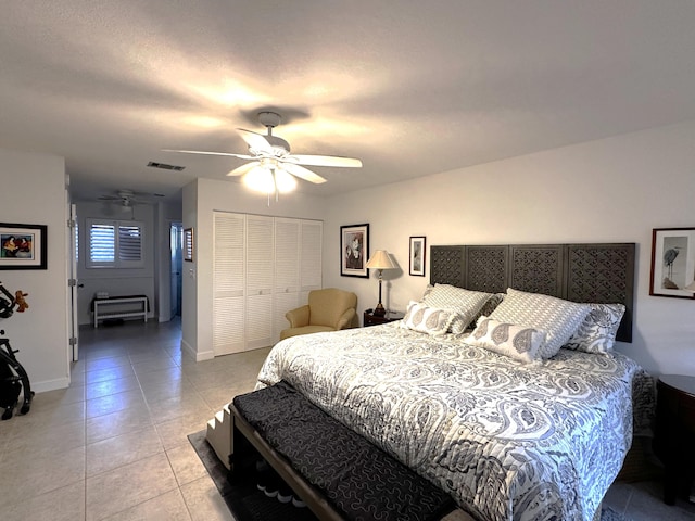 tiled bedroom with ceiling fan and a closet