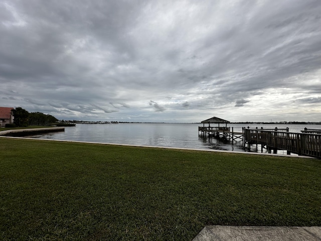 view of dock featuring a water view and a yard