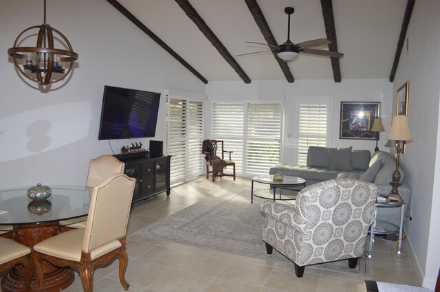 tiled dining space featuring ceiling fan with notable chandelier and vaulted ceiling