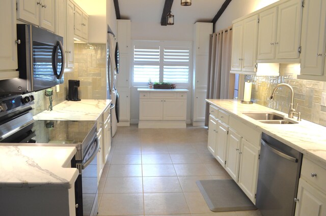 kitchen featuring stacked washer and dryer, stainless steel appliances, and white cabinets