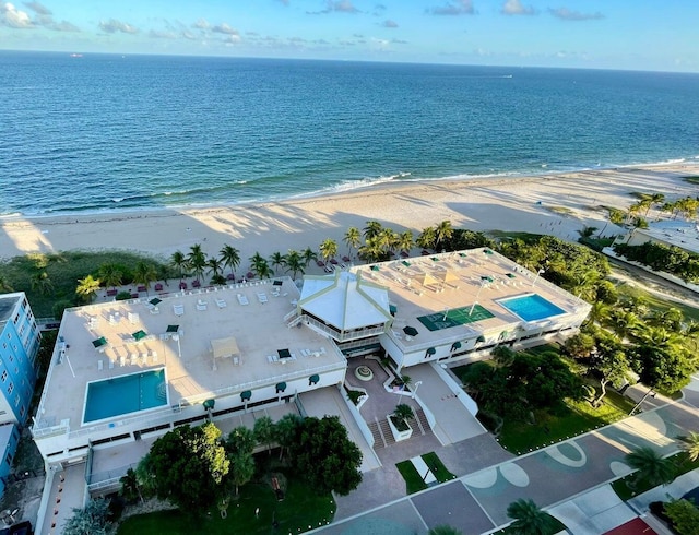 birds eye view of property with a water view and a view of the beach