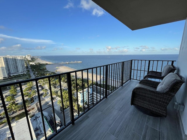 balcony with a water view and a view of the beach