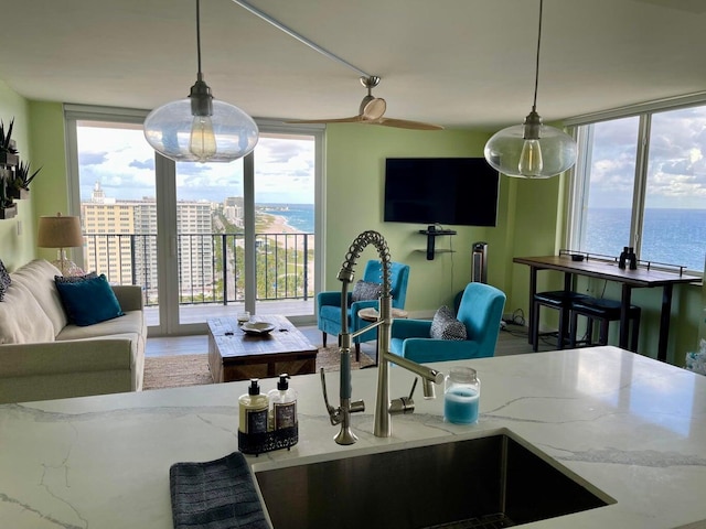 living room featuring expansive windows, plenty of natural light, and sink