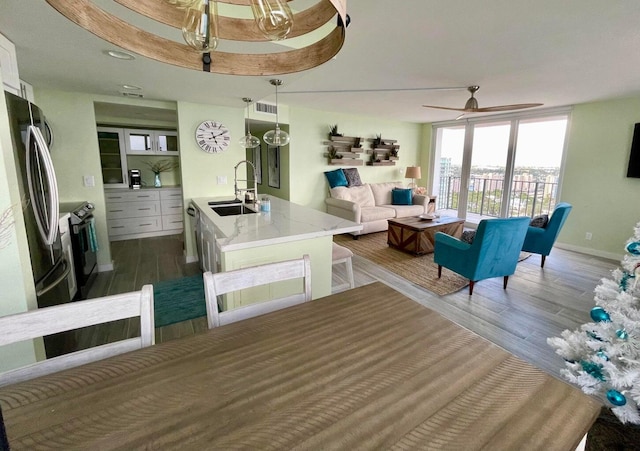 living room featuring ceiling fan, hardwood / wood-style floors, and sink