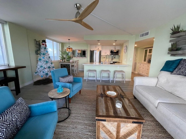 living room featuring ceiling fan and dark hardwood / wood-style flooring