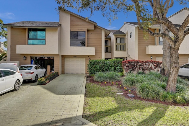 view of property with a garage and a front lawn