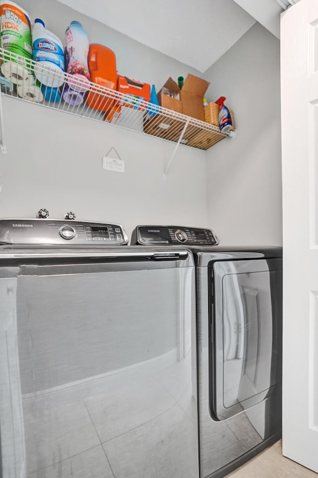 laundry room with light tile patterned floors and washer and clothes dryer