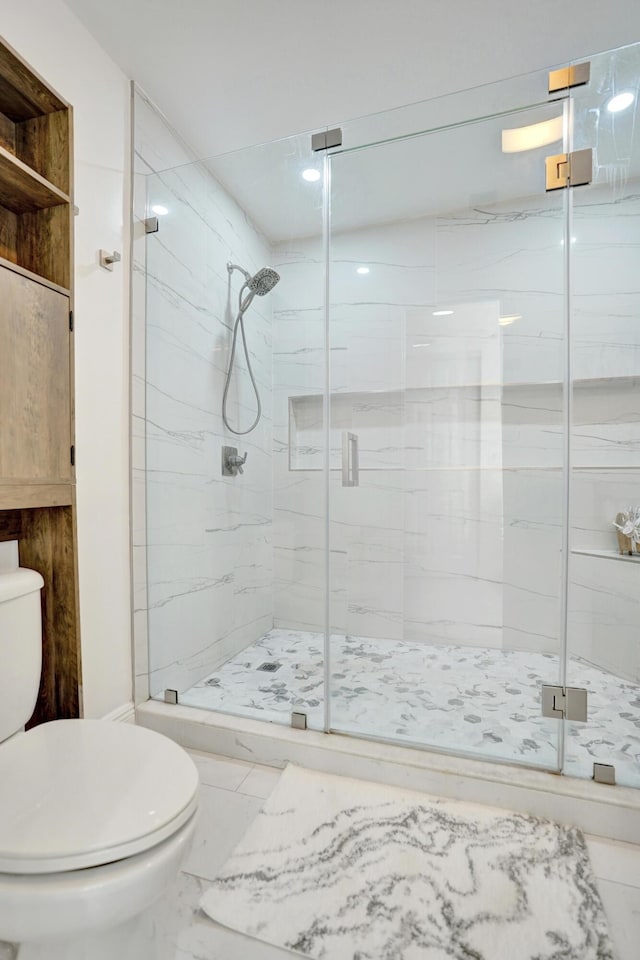 bathroom with a shower with door and toilet