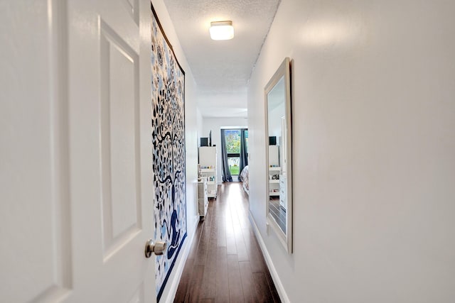 hallway featuring dark hardwood / wood-style flooring and a textured ceiling