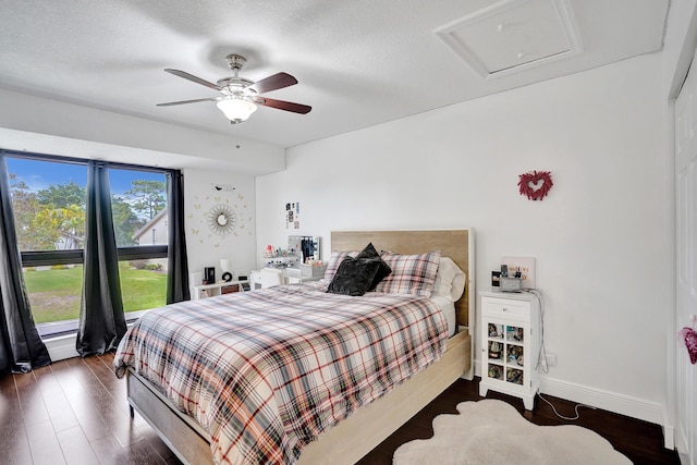 bedroom featuring ceiling fan, dark hardwood / wood-style floors, and a textured ceiling