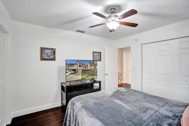 bedroom featuring ceiling fan, dark wood-type flooring, a textured ceiling, and a closet