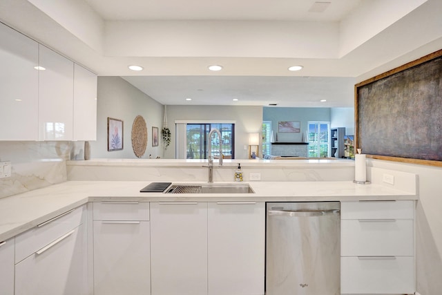 kitchen featuring backsplash, stainless steel dishwasher, sink, and white cabinets