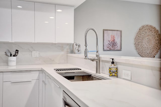 kitchen featuring white cabinetry, sink, and backsplash