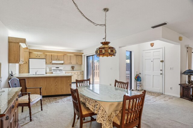 dining room with light carpet and sink