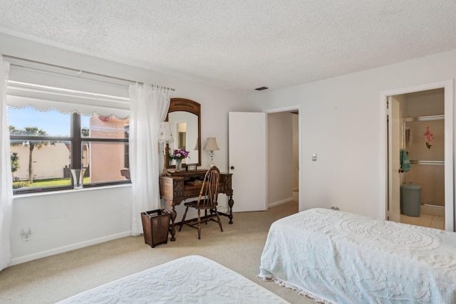 bedroom with connected bathroom, light colored carpet, and a textured ceiling