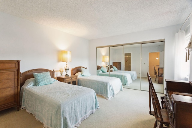 carpeted bedroom with a textured ceiling and a closet