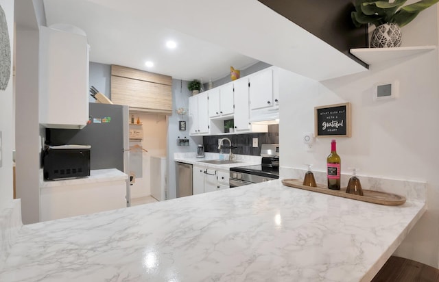 kitchen featuring sink, white cabinetry, backsplash, stainless steel appliances, and ventilation hood