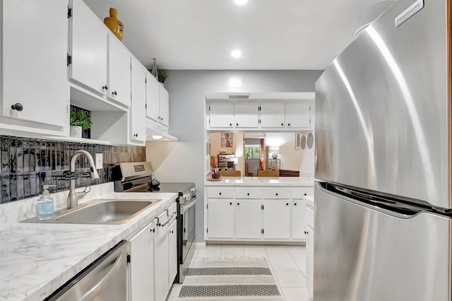 kitchen featuring white cabinetry, stainless steel appliances, light tile patterned flooring, and sink