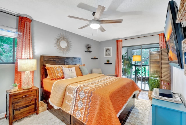 bedroom with a textured ceiling, access to outside, and ceiling fan