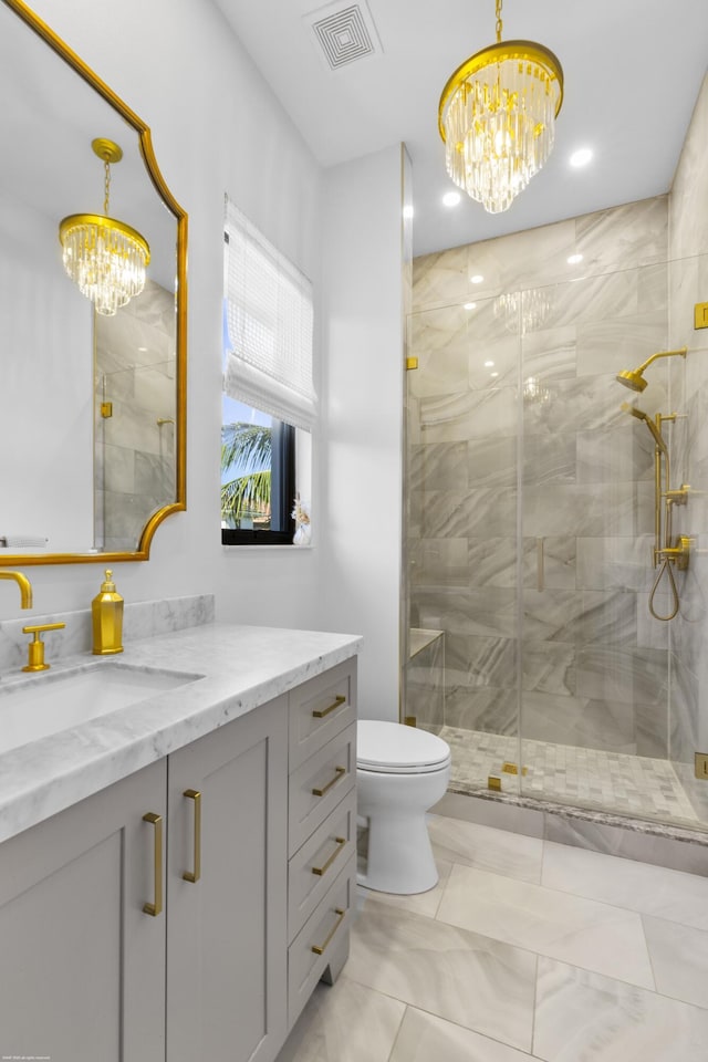 bathroom featuring vanity, an inviting chandelier, toilet, and walk in shower