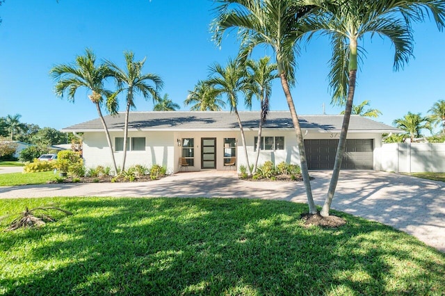 ranch-style house featuring a front lawn and a garage