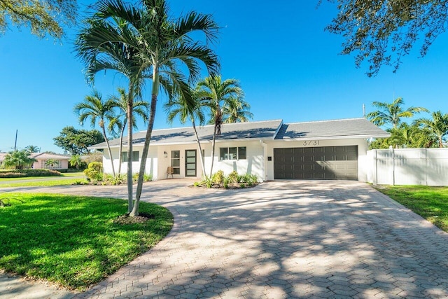 ranch-style house featuring a garage and a front yard