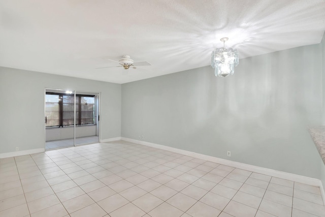 tiled empty room with ceiling fan with notable chandelier